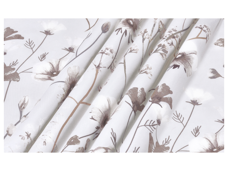 White fabric with a delicate brown floral pattern, draped in soft folds.