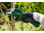 Green electric pruning shears cutting a tree branch, held by a gloved hand.