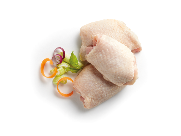 Raw chicken thighs with celery, carrots, and red onion on a white background.