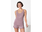 Woman in mauve pajama set with lace-detailed camisole and polka dot shorts.