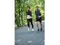 Two runners in sportswear jogging outdoors, woman in a jacket and man in a vest.