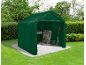 Green garden shed with a barbecue, folding chairs, boots, and a shovel.