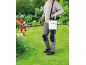 Person spraying roses with a backpack sprayer in a garden.