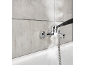 Steam cleaner cleaning a bathroom faucet and tiles above a bathtub.
