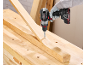 A person using a cordless drill to screw into a wooden plank on a workbench.