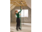 Woman installing adjustable ceiling props in an attic under construction.