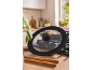 Kitchen stove with a pan and a glass lid, ready for cooking.