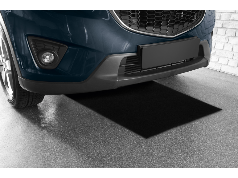 Dark blue car parked in a garage with a black mat underneath it.