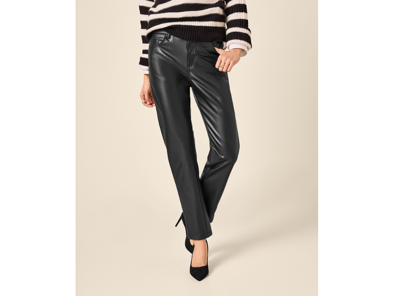 Woman in striped sweater and black faux leather trousers with heels.