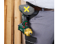 Person wearing work trousers with an impact driver and battery pack attached to their belt.