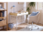 Home office with a light wood desk, white chair, and wooden bookshelf with books and baskets.