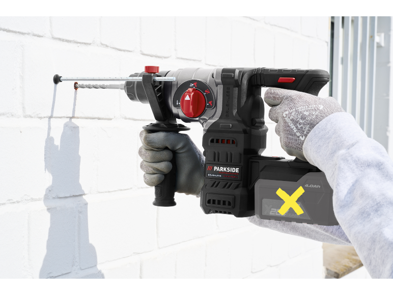 Cordless hammer drill drilling into a white brick wall