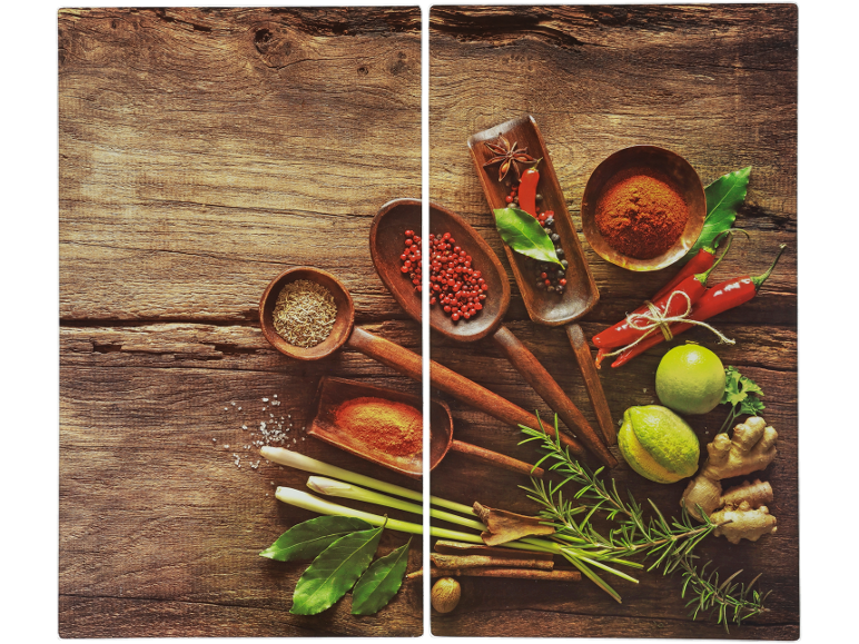 Spices and herbs like chilies, limes, ginger, and rosemary on wood.
