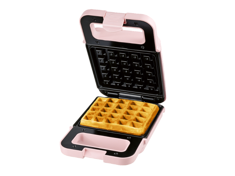 Pink waffle maker with an open lid and a baked waffle