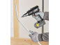 Man in gloves using a cordless power tool to bend a plastic pipe.