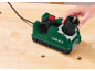 Drill bit sharpener on a wooden workbench, hand inserting a drill bit into the sharpener.