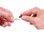 Hands connecting electrical wires to a black connector.