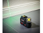 Green laser level projecting horizontal and vertical lines on a wall and floor.