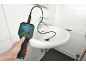 Inspection camera in hand, probe in a sink, displaying a pipe view on screen.