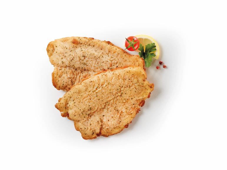 Breaded fish fillets with lemon, tomato, and parsley.