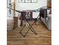 Black clothes drying rack with various clothes in a modern living room.