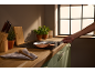 Modern kitchen with a frying pan on a hob, a hand holding the pan.