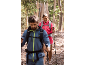Couple in hiking apparel and backpacks walking on a forest path.
