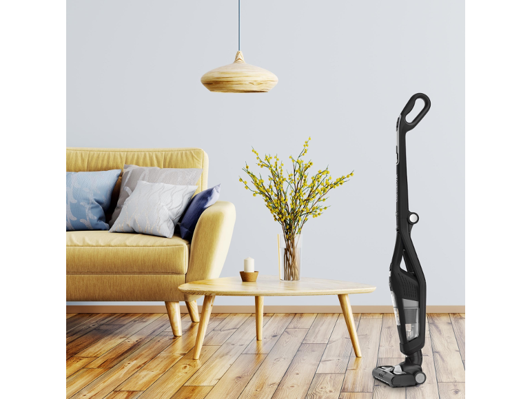 Cordless vacuum cleaner in a living room with a yellow sofa and wooden coffee table.