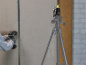 Worker using a drill and a laser level on a construction project.