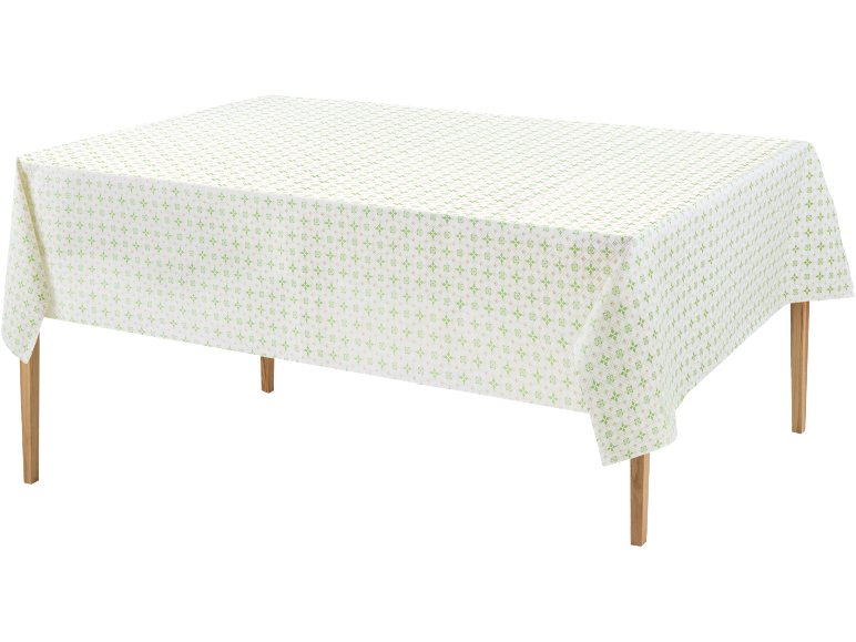 White tablecloth with green and beige geometric pattern on a wooden table.