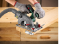 Person in gloves cutting a wooden board with a handheld circular saw.