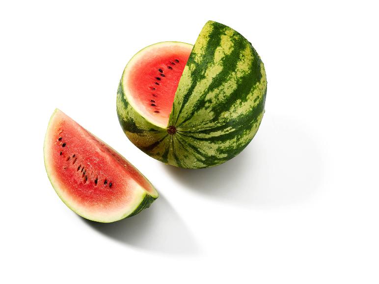 Sliced watermelon with red flesh and seeds on a white background.