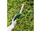 Electric hedge trimmer cutting a green hedge with a gloved hand.