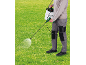 Person spraying grass with a garden sprayer with a shoulder strap.