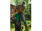 Man with green and red garden shredder, shredding branches in a sunny garden.