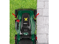 Overhead shot of a lawnmower on grass next to a concrete pavement, with red arrows indicating edges.