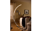 Curved LED floor lamp in a modern living room with a sofa and decor.