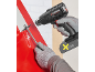 Cordless heat gun and scraper removing paint from a red surface.