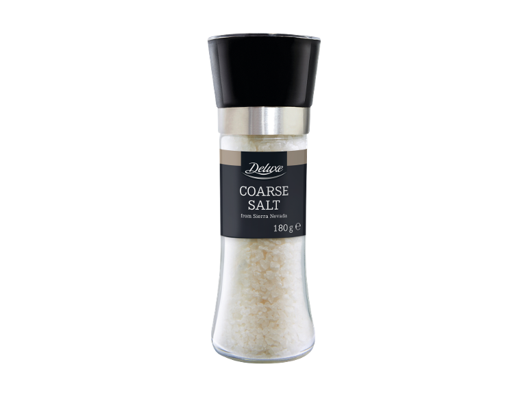 Coarse salt in a glass grinder with a black lid, labeled 
