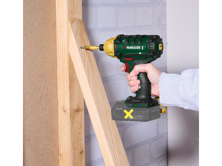 Cordless impact driver screwing a screw into a wooden construction.