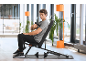 Man uses a massage gun while sitting on an exercise bench in a modern gym.