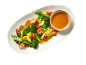 Colorful stir-fried vegetables with mushrooms and a side of peanut sauce on an oval plate.