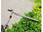 Person trimming bushes with a telescopic hedge trimmer.