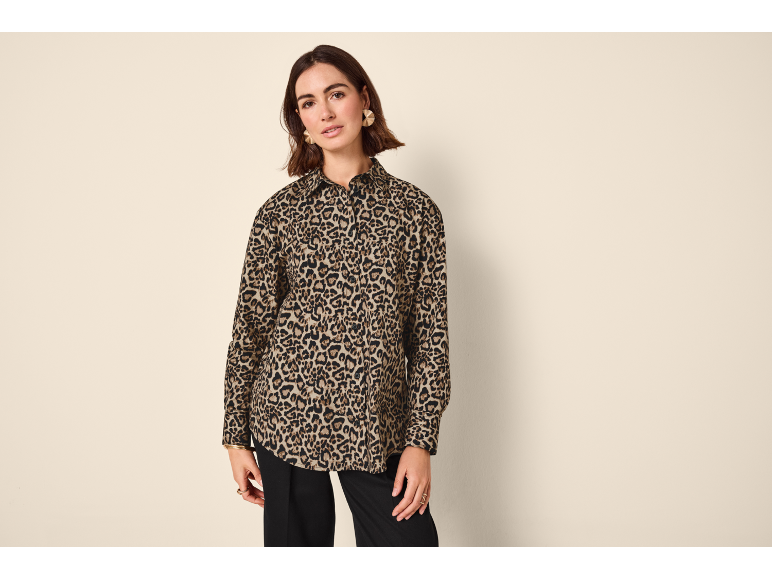 Woman in a leopard print shirt and black trousers.