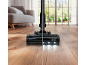 Cordless vacuum cleaner with LED lights cleaning a wooden floor, with a sofa in the background.