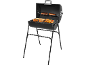 Black charcoal grill with sausages, meat, and vegetable skewers on the grate.
