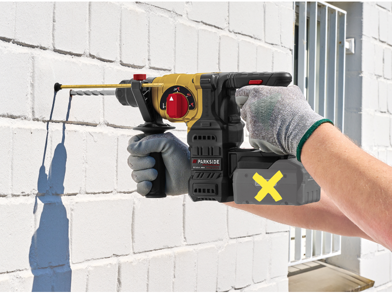 Person drilling into a white brick wall with a cordless rotary hammer drill.