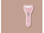 Pink electric callus remover on a beige background.