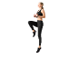 Woman in black sports top and leggings, exercising.