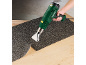 Man using a heat gun to remove flooring from a light wooden surface.